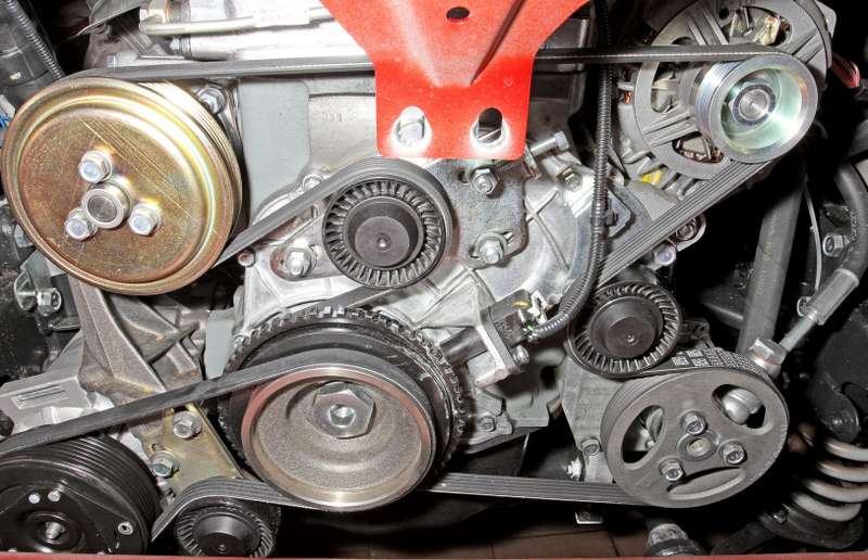 Расположение ремня привода вспомогательных агрегатов и гаек крепления кронштейна натяжного ролика (для наглядности показано при снятом радиаторе системы охлаждения двигателя).