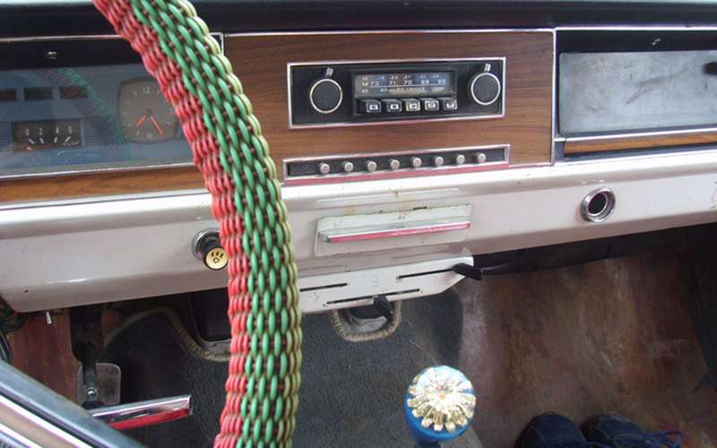 Типичные элементы салона начала 1970-х: оплетка на руль и цветочек на рычаг переключения передач.